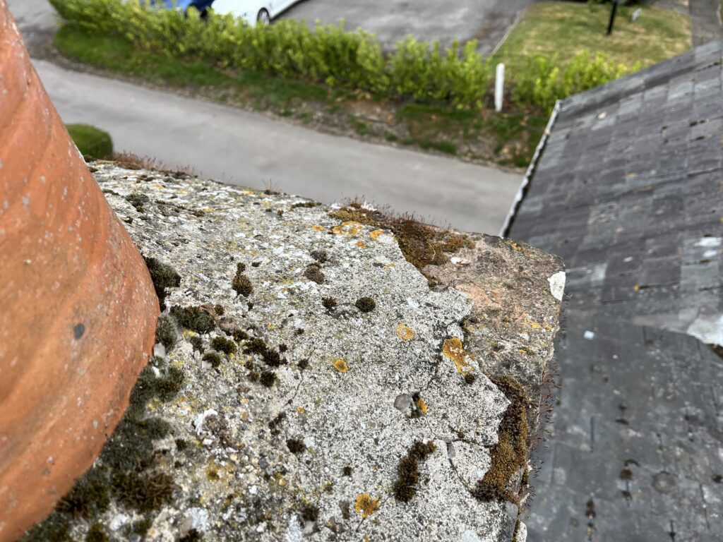 Cracked chimney flaunching letting rain into the flue on a brick stack